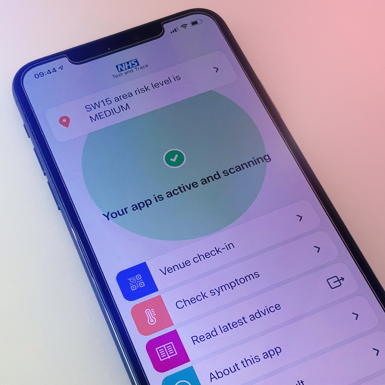 Smartphone screen displaying a COVID-19 NHS test and trace app with the message 'Your app is active and scanning' and a green check mark. The top of the screen shows the time 09:44 and the area risk level is medium.