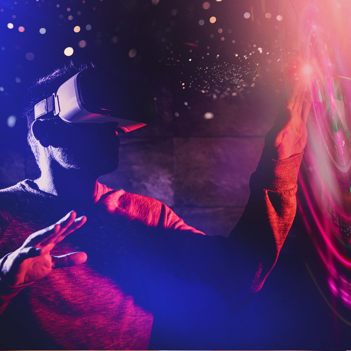 A man wearing a virtual reality headset in a dark room with colorful lights and digital effects.